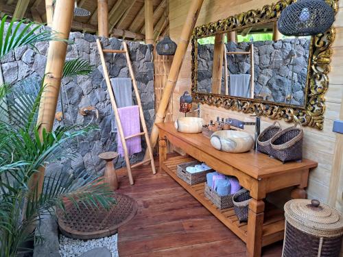 a bathroom with a mirror and a wooden table at Villas Bukit Lipah in Amed