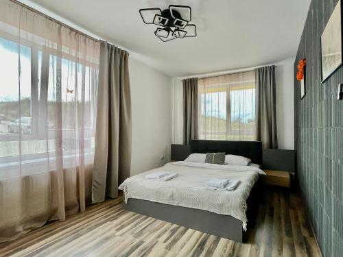 um quarto com uma cama e uma grande janela em YamaLux Apartments - Cozy Double - WestSide 3 em Floresti