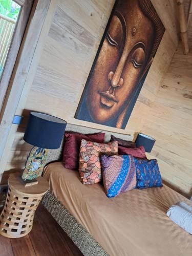 a room with a couch with a large painting on the wall at Villas Bukit Lipah in Amed