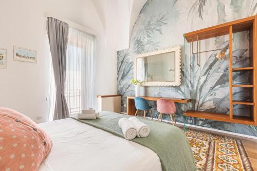 een slaapkamer met een bed met een spiegel en een bureau bij B&B Palazzo Flora in Collepasso