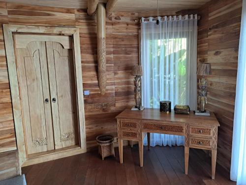 a wooden room with a desk and a window at Villas Bukit Lipah in Amed