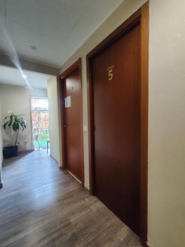 an empty hallway with two brown doors and a floor at Hotel Convertini in Milan