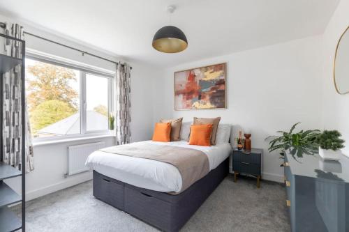a bedroom with a large bed and a window at Stunning 4 Bed 3 Bathroom Home 