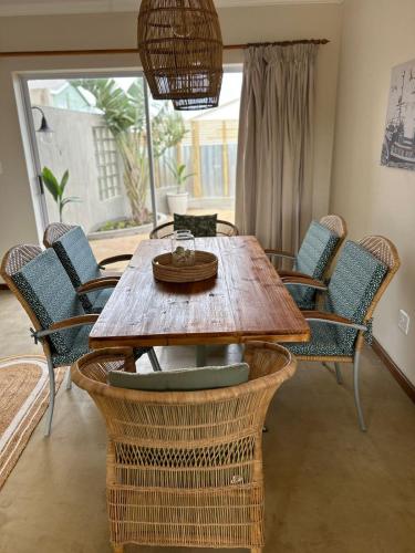 a wooden table with chairs and a dining room at Secrets 1 at Waterkant 7 in Jeffreys Bay