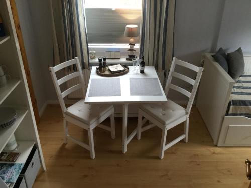 una mesa de comedor blanca y sillas en una habitación en von Fehrn, en Nortorf