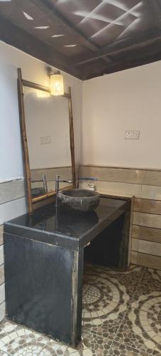 a bathroom with a sink and a mirror at Samyama Retreat in Cola