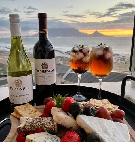 a plate of food with two glasses of wine at Abode Africa in Bloubergstrand