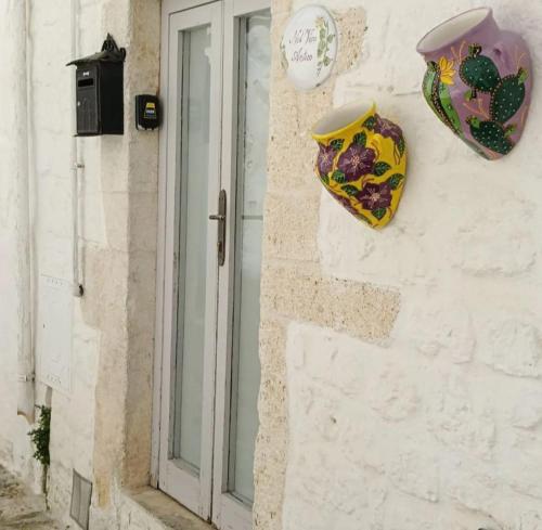 a window of a building with vases on the wall at Nel Vico Antico in Ostuni