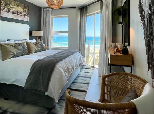 a bedroom with a bed and a view of the ocean at Abode Africa in Bloubergstrand