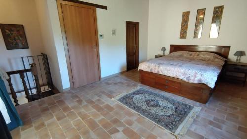 ein Schlafzimmer mit einem Bett und einem Teppich auf dem Boden in der Unterkunft Podere Cerrete - Eco Farmhouse in Castel del Piano