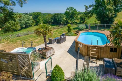 une cour arrière avec une piscine et un bain à remous dans l'établissement Situé en plein coeur de la campagne, à Fougerolles