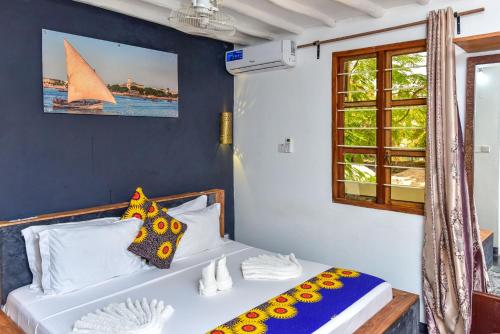 a bedroom with a bed with a sailboat on the wall at Barabara house in Jambiani