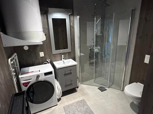 un bagno con doccia e lavatrice di Ny leilighet på Norefjell - ski in/out a Noresund