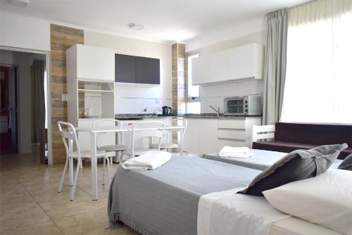 um quarto de hotel com duas camas e uma cozinha em La Gioconda Apart Hotel em Villa María