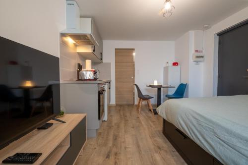 Cet appartement comprend une chambre avec un lit et une cuisine avec une table. dans l'établissement #Nouveau#Cocoon#Wifi#Parking#Biendormiracognac, à Cognac