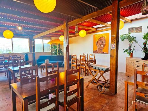 a restaurant with wooden tables and chairs and a painting at Domaine de l'Anse in Petite Île