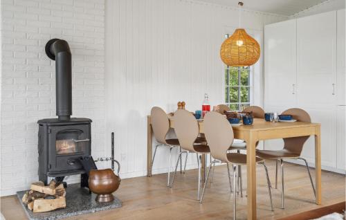 a dining room with a wood stove and a table at Three-Bedroom Holiday Home In Knebel in Knebel
