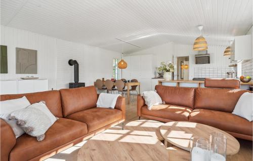 a living room with brown leather couches and a table at Three-Bedroom Holiday Home In Knebel in Knebel