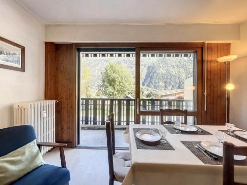 une salle à manger avec une table et une grande fenêtre dans l'établissement T2 45m² 2/4 pesonnes centre chamonix - FR-1-507-27, à Chamonix-Mont-Blanc