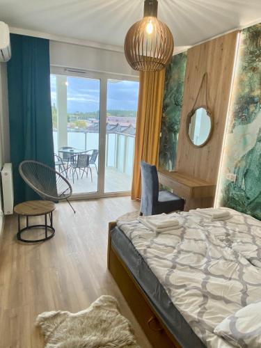 a bedroom with a bed and a balcony at Apartamenty Białe nad jeziorem Białym in Augustów