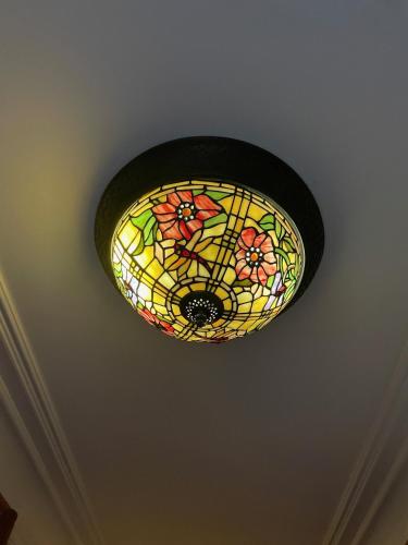a stained glass light fixture hanging from a ceiling at Villa Eckhoff in Stavanger