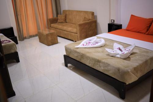 una camera con un letto, una sedia e un bagno. di Kana Kato a Aswan