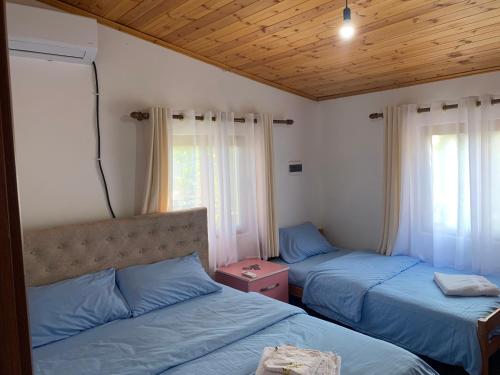 - une chambre avec 2 lits jumeaux et un plafond en bois dans l'établissement Vila Deda Tale, à Lezhë