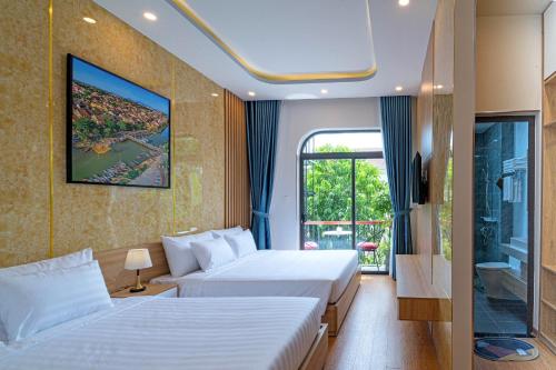 een hotelkamer met 2 bedden en een raam bij Mint Hoi An Villa in Hội An