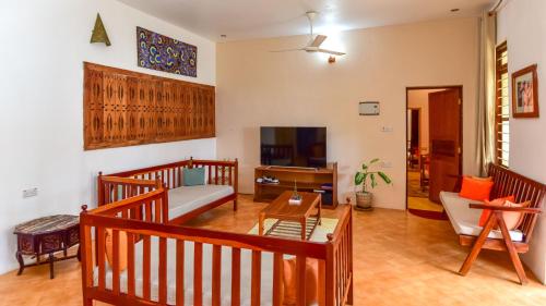 a living room with a couch and a tv at Barabara house in Jambiani