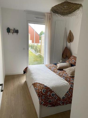 une chambre avec un lit dans une pièce avec une fenêtre dans l'établissement Cancoon - location appartement de vacances Cancale, à Cancale