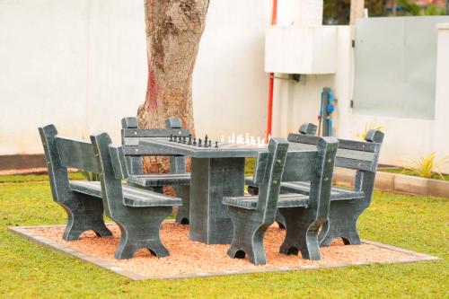 dos bancos y una mesa con ajedrez. en Rhome Home en Weligama