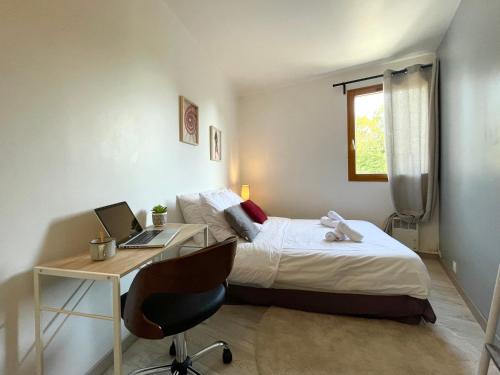 a bedroom with a bed and a desk with a laptop at * Chic Business Evasion * - SOnights in Brétigny-sur-Orge