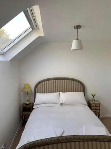 a bedroom with a large bed with a window at Rose Cottage Glastonbury in Glastonbury