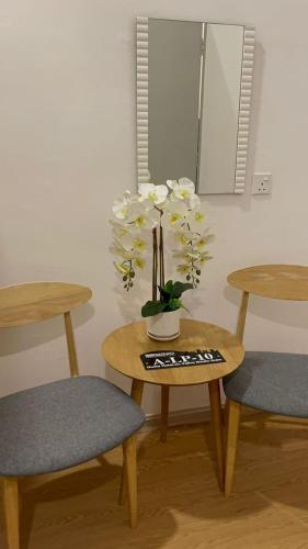 a table with two chairs and a vase with flowers on it at Husfa Modern Oasis Mahkota Valley in Kuantan