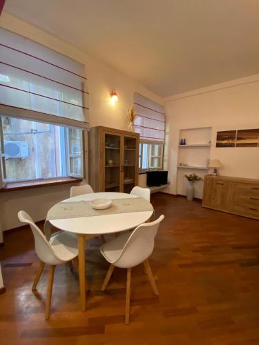 a dining room with a white table and chairs at PM 2 Via Scano Guest House B in Sassari