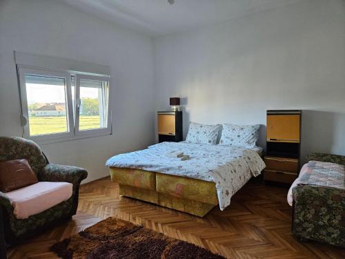 1 dormitorio con 1 cama y 2 sillas en Apartman Gajic, en Nikšić