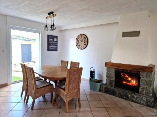 une salle à manger avec une table et une cheminée dans l'établissement Holiday Home in Binic near Sandy Beach, à Binic