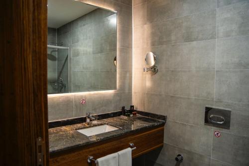 Parwar Hotel في دهوك: حمام مع حوض ومرآة