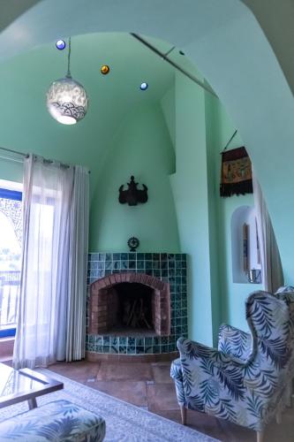 a living room with a fireplace and two chairs at Lazib Inn Resort & Spa in Tunis