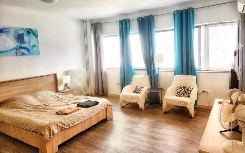 - une chambre avec des rideaux bleus, un lit et deux chaises dans l'établissement ATTIKI metro 200m Cooking and laundry Comfort and convenience, à Athènes