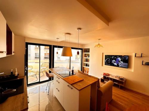 a living room with a kitchen with a counter top at Pepite Coeur 7ème Tout Confort - Clim - Parking in Marseille