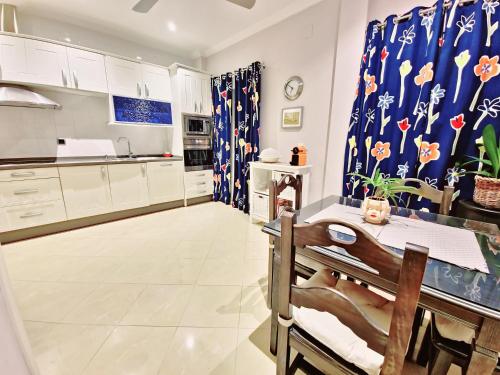 a kitchen with white cabinets and a dining table at Casa Mejorana in Hinojos