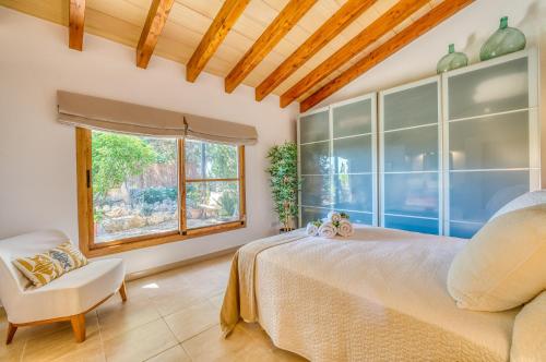a bedroom with a bed and a chair and a window at Ideal Property Mallorca - Can Davero in Binissalem