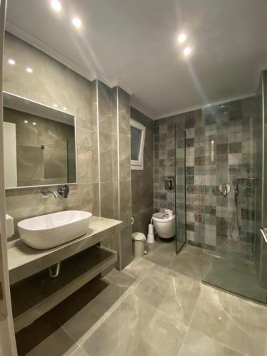 a bathroom with a sink and a shower and a toilet at NAMARE AQUA in Skala Sotiros