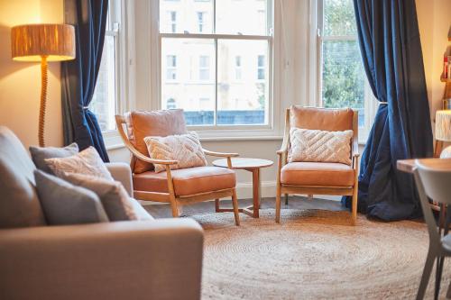 a living room with two chairs and a couch and a window at South Bay Garden Apartment in Scarborough