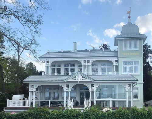 a large white house with a tower on top of it at Villa Svanen am Meer in Timmendorfer Strand