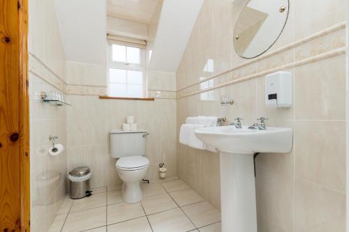 uma casa de banho com um lavatório, um WC e um espelho. em Michaeleen's Manor B&B em Cong