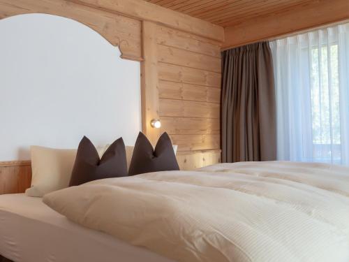 a bedroom with a white bed with a window at Hotel Garni Panorama in Scuol