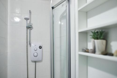 a shower with a glass door in a bathroom at South Bay Garden Apartment in Scarborough