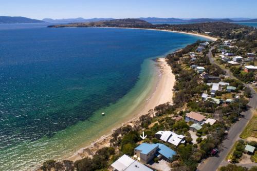an aerial view of a beach with houses and the ocean at South Arm Beach House in South Arm